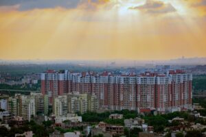 A modern and vibrant cityscape of Noida, India, featuring high-rise buildings, metro rail, expressways, and lush green spaces, showcasing Noida as a thriving IT and business hub.